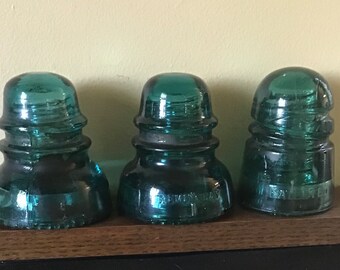 Set of three Hemingray dark aqua glass insulators - Two No. 40s and one October 8th 1907 spiral style