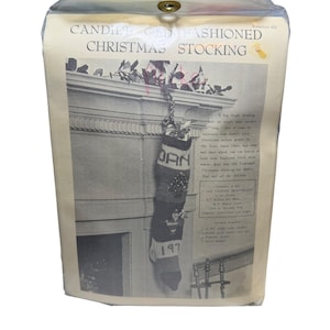 May include: A vintage Christmas stocking kit in a clear plastic package. The package features a black and white image of a knitted stocking hanging from a mantel. The stocking is personalized with the name "DAN" and the year "197". The package text reads "CANDILEGED HASHIONED CHRISTMAS STOCKING".