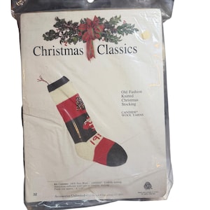May include: A Christmas Classics kit featuring an old-fashioned knitted Christmas stocking. The stocking has red, black, and white sections with a Christmas tree and the number 19. The finished size is approximately 6 x 24 inches.