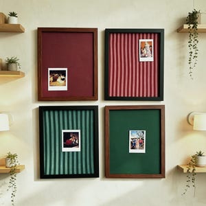 Puede incluir: Cuatro tableros de anuncios rectangulares montados en la pared con marcos. Dos marcos son de madera oscura, dos son negros. Los tableros presentan superficies de tela en color granate sólido, verde oscuro sólido, rayas granates y blancas, y rayas verdes y blancas.