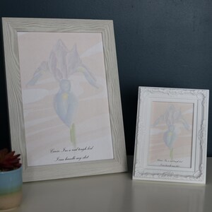 May include: Two framed prints of a watercolor painting of a blue iris flower. The larger print has the text "Cause I'm a wild bright bird I can handle my own dirt".