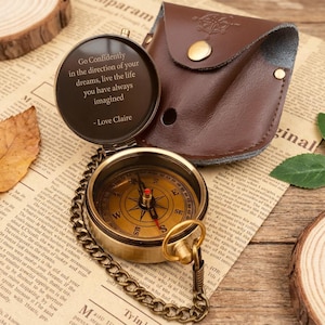 May include: A vintage brass compass with a leather case. The compass is open, revealing a detailed dial and a quote: "Go Confidently in the direction of your dreams, live the life you have always imagined - Love Claire."