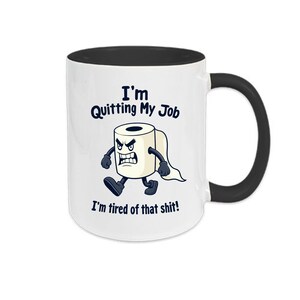 Könnte beinhalten: Weiße Keramik-Tasse mit schwarzem Innenraum und Henkel. Die Tasse zeigt den Text "I'm Quitting My Job" und "I'm tired of that shit!" zusammen mit einem Cartoon-Bild einer wütenden Toilettenpapierrolle.