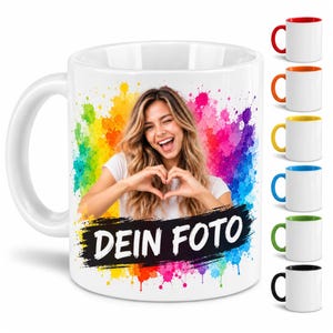 Könnte beinhalten: Ein weißer Keramikbecher mit einem bunten Regenbogen-Farbspritzer-Design. In der Mitte ist ein Foto einer Person zu sehen, die mit ihren Händen ein Herz formt. Unter dem Foto befindet sich ein schwarzer Pinselstrich mit dem Text DEIN FOTO.