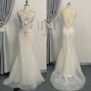 Elegant And Modern Off-White Sleeveless Mermaid Wedding Dress With Sparkling Beads And a Classic Corset Lace-Up Design Flatter Figure