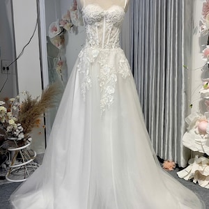 Elegant And Modern Off-White Sleeveless Mermaid Wedding Dress With Sparkling Beads And a Classic Corset Lace-Up Design Flatter Figure