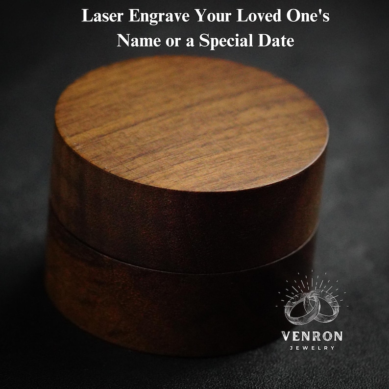 May include: A round wooden ring box with a lid. The box is made of dark brown wood and has a smooth finish. The lid has a slightly raised edge. The box is sitting on a dark surface. The text "Laser Engrave Your Loved One's Name or a Special Date" is at the top of the image. The text "VENRON JEWELRY" is at the bottom of the image.
