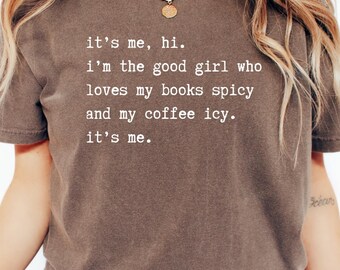 May include: A brown t-shirt with the text "it's me, hi. i'm the good girl who loves my books spicy and my coffee icy. it's me." printed in white.