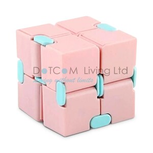 May include: A pink and blue infinity cube fidget toy. The cube is made of eight connected blocks, each with a pink exterior and light blue accents. The text "DOTCOM Living Ltd" and "living without limits" is visible on the cube.