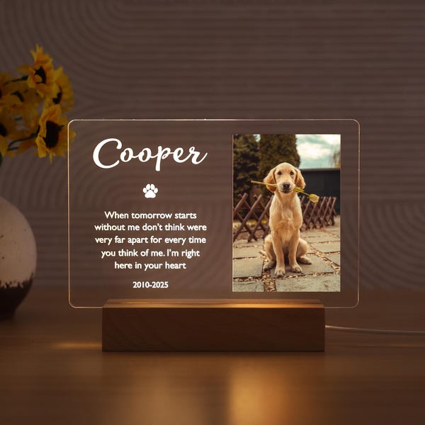 Pode incluir: Placa memorial iluminada com o nome "Cooper" e uma foto de um golden retriever com uma flor. A placa inclui uma pegada e uma mensagem sentimental, em uma base de madeira.