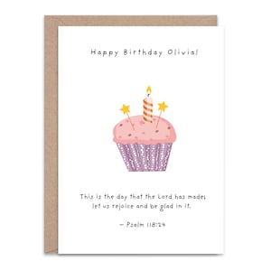 May include: A birthday card featuring a cupcake illustration. The card says "Happy Birthday Olivia!" and includes a Bible verse from Psalm 118:24. The cupcake has pink frosting, a purple liner, and a lit candle.