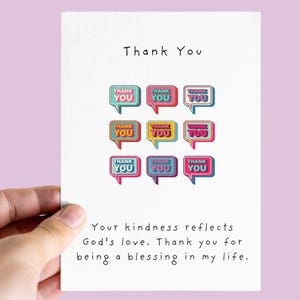 Könnte beinhalten: Weiße Dankeskarte mit dem Schriftzug "Thank You" oben. Die Karte zeigt neun farbige Sprechblasen mit den Worten "Thank You" darin. Der untere Teil der Karte enthält eine Botschaft über Freundlichkeit und Segen.