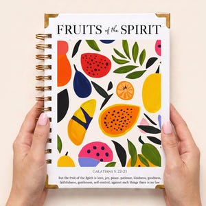 May include: A spiral-bound notebook with a white cover featuring the text FRUITS of the SPIRIT at the top and Galatians 5: 22-23 at the bottom. The cover displays a colourful pattern of abstract fruits and green leaves in red, orange, yellow, and pink.