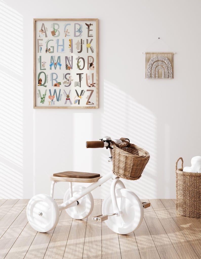 May include: White tricycle with a brown seat and a wicker basket. The tricycle is in a room with a white wall and a framed alphabet poster with illustrations.