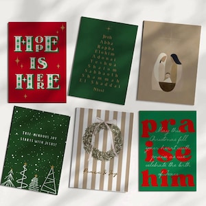 Könnte beinhalten: Eine Sammlung von sechs Weihnachtskarten mit festlichen Designs. Die Karten zeigen Botschaften wie „Er ist hier“, eine Liste von Namen, eine Krippenszene, Weihnachtsbäume, einen Kranz und das Wort „Lob“. Die Karten sind in Rot, Grün und Beige.