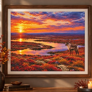 May include: A framed landscape print featuring a reindeer standing in a vibrant autumn tundra at sunset. The scene displays a winding river reflecting the orange and purple sky, surrounded by red, yellow, and orange foliage under a bright sun.