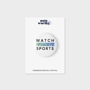 May include: A white button with the text "WATCH WOMEN'S SPORTS" in black outlined text. The text "WOMEN'S" is in a blue and green gradient. The button is on a white background with the text "noteworthy" in black at the top.