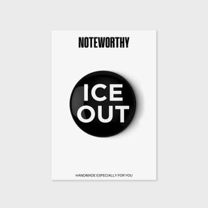 以下が含まれることがあります： 白い背景に、白い文字で「ICE OUT」と書かれた黒いボタン。ボタンの上には「NOTEWORTHY」、下には「HANDMADE ESPECIALLY FOR YOU」と書かれています。