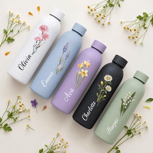 May include: Five cylindrical metal water bottles in white, light blue, lavender, black, and sage green. Each bottle features a unique floral illustration and a personalised name in white script: Olivia, Emma, Ava, Charlotte, and Harper.