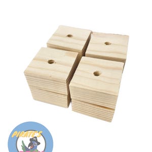 May include: Set of four unfinished wooden squares with a hole drilled in the center of each. The squares are approximately 2 inches by 2 inches.