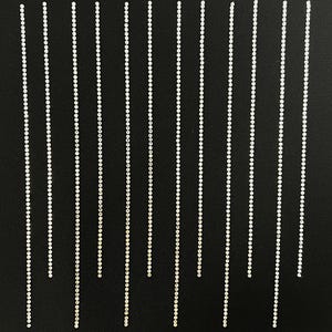 May include: A black background with multiple rows of silver rhinestones arranged in vertical lines.
