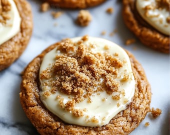 May include: Close-up of a gingerbread cookie topped with a white cream cheese frosting and sprinkled with brown sugar.