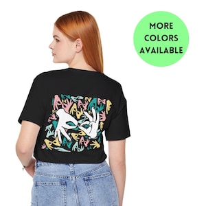 May include: Black t-shirt with a white graphic print of hands forming a heart shape on the back. The graphic is surrounded by smaller hand prints in various colors, including pink, teal, and yellow.