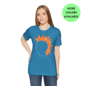 May include: A teal blue t-shirt with a white outline of a person's head with an orange mohawk made of hand signs.