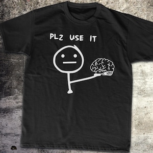 Puede incluir: Camiseta negra con texto blanco que dice "PLZ USE IT" y un figurín sosteniendo un cerebro.