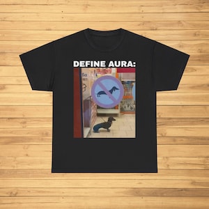 May include: Black t-shirt with the text "DEFINE AURA:" and a photo of a dachshund walking past a sign that says "Dogs must be on a lead".