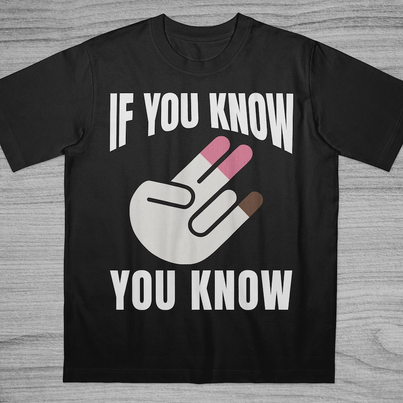 May include: Black t-shirt with the text "IF YOU KNOW YOU KNOW" in white. The shirt features a graphic of a hand with two fingers painted pink and one finger painted brown.