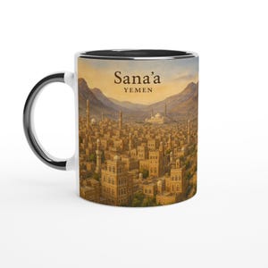 May include: White ceramic mug with a black interior and handle. The mug features a detailed illustration of Sana'a, Yemen, with the city's architecture and landscape. The text "Sana'a YEMEN" is printed at the top of the mug.
