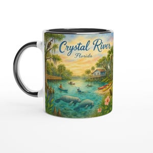 Op de afbeelding: Witte keramische mok met een zwarte binnenkant en handvat, met een schilderachtige illustratie van Crystal River, Florida. Het ontwerp bevat zeekoeien, kajakkers en de tekst "Crystal River Florida". De mok heeft een glanzende afwerking.