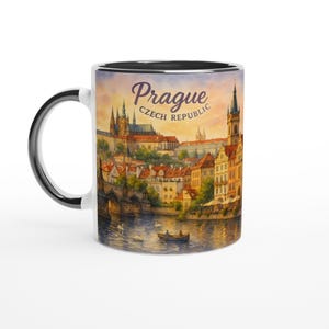 Può includere: Tazza in ceramica bianca con un'illustrazione ad acquerello di Praga, Repubblica Ceca. Il design include lo skyline della città, un fiume con barche e cigni e il testo "Prague Czech Republic". La tazza ha interno e manico neri.