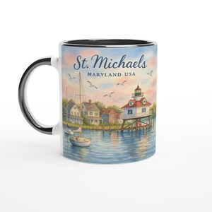 May include: White ceramic mug with a black handle and rim. The mug features a watercolour illustration of St. Michaels, Maryland, USA, with a lighthouse, sailboat, and the text "St. Michaels, Maryland USA". The background shows a sunset sky and water.