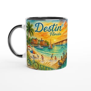 May include: White ceramic mug with a black interior and handle. The mug features a colourful watercolour illustration of a beach scene with the text "Destin Florida". The design includes a bridge, boats, and people.