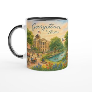 May include: White ceramic mug with a black interior and handle, featuring a watercolor illustration of Georgetown, Texas. The design includes a courthouse, river, and the text "Georgetown Texas".