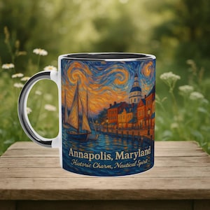 May include: White ceramic mug with a black interior and handle. The mug features a colorful illustration of Annapolis, Maryland, with sailboats, buildings, and the text "Annapolis, Maryland Historic Charm, Nautical Spirit."