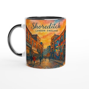 May include: White ceramic mug with a black handle and rim. The mug features a watercolour illustration of a street scene in Shoreditch, London, England, with the text "Shoreditch LONDON ENGLAND" in a decorative font.