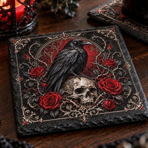 May include: A square slate coaster featuring a detailed illustration of a black raven perched atop a human skull. The design is surrounded by vibrant red roses, thorny vines, and intricate gold filigree accents set against a dark background.