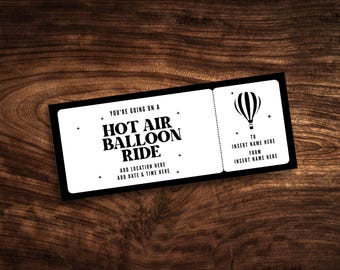 Könnte beinhalten: Ein rechteckiges weißes Ticket mit schwarzem Rand, das den Text YOU'RE GOING ON A HOT AIR BALLOON RIDE, ADD LOCATION HERE, ADD DATE & TIME HERE, TO INSERT NAME HERE, FROM INSERT NAME HERE sowie eine Grafik eines Heißluftballons enthält.