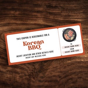 Puede incluir: Un cupón rectangular con borde naranja y fondo de madera. El cupón dice "Korean BBQ" en letras grandes y estilizadas. Incluye espacio para insertar detalles y un gráfico de barbacoa coreana.