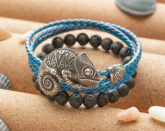 May include: A blue leather bracelet with a silver chameleon charm and black lava rock beads.