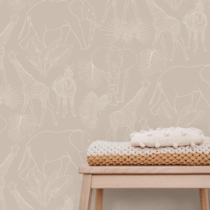 May include: A beige wallpaper with a white outline pattern of various safari animals, including giraffes, zebras, and elephants. A wooden stool with a white and beige knitted blanket on top is in the foreground.