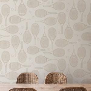 May include: A dining room with a light beige wall featuring a repeating pattern of tennis rackets and tennis balls. Four wicker chairs surround a wooden table.