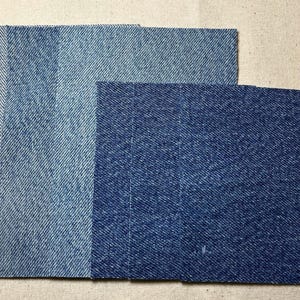 May include: Four different shades of blue denim fabric swatches. The swatches are arranged in a row from lightest to darkest.
