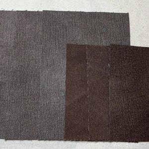 Puede incluir: Dos muestras de tela, una gris oscuro y otra marrón, se colocan una al lado de la otra. Las muestras son texturizadas y tienen un aspecto tejido.