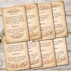 May include: Set of vintage-style cards with Bible verses and floral accents. Each card features a quote and a reflection, with a cream background and decorative pink roses. The cards are arranged on a wooden surface.