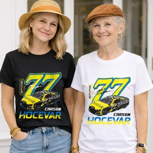 May include: Two t-shirts, one black and one white, each with a racing car design. The design includes the number 77 in yellow and blue, a car graphic, and the name "CARSON HOCEVAR". The shirts are worn by two people.