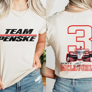 Könnte beinhalten: Ein weißes T-Shirt mit dem Text "TEAM PENSKE" in Schwarz mit einem roten Strich darüber. Die Rückseite des Shirts hat eine rote Nummer "3" mit einem roten IndyCar-Rennwagen in der Nummer. Der Text "SCOTT MCLAUGHLIN" befindet sich unter der Nummer.